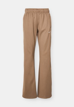 Brown athletic pants with a relaxed fit, elastic waistband, and side pockets. Features a white Nike logo on the left thigh. Smooth texture.