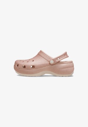 Sabot en résine rose avec un design perforé, une bride ajustable à l'arrière, un dessus texturé et une semelle intérieure contournée. Forme légère et confortable.