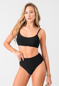 Conjunto de bikini negro texturizado que incluye una parte superior con escote en forma de scoop y tirantes delgados, junto con una parte inferior de cintura alta; tejido suave con detalles de costura contorneada.