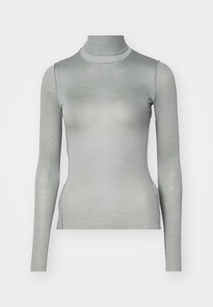 Ilgi piedurkņu turtlenecks krekls, izgatavots no maigas gaiši pelēkas auduma. Iespējas: pieguloša piegriezuma ar augstu apkakli un bezšuvēm sānos, kas izceļ gludu tekstūru.