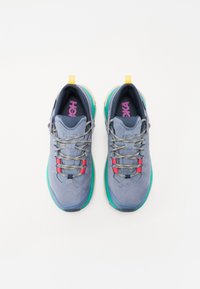 Scarpe da ginnastica grigie con accenti turchesi, superficie texturizzata e lacci multicolori; presentano un collarino imbottito e un logo sulla soletta.