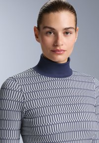 Golf z granatowym kołnierzem, teksturowanym wzorem naprzemiennych granatowych i jasnych pasków, dopasowany fason z lekkiego materiału.