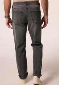 Szare dżinsy o luźnym kroju, z dwoma tylnymi kieszeniami i podwiniętymi mankietami. Gładka tekstura z delikatnym wyblaknięciem. Możliwe skórzane akcenty.