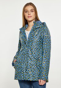 Lepardo raštas, atsparus vandeniui, striukė su mėlynu fonu, žaliais ir juodais taškeliais, užtrauktuko uždarymu ir šoninėmis kišenėmis.