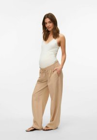 Completo per maternità composto da una canotta beige chiaro con pizzo e pantaloni beige larghi con vita elastica e tasche laterali.