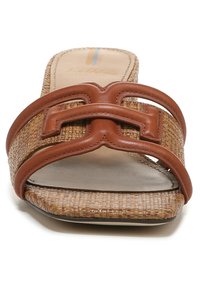 Sandal in tessuto intrecciato color beige con cinturino in pelle marrone che presenta un design decorativo a doppia "H". Suola piatta, stile open-toe e finitura testurizzata.