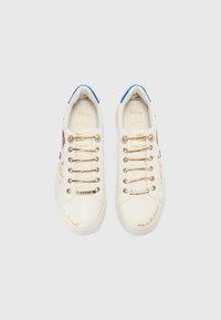 Sneaker bianchi con una texture liscia, dotate di dettagli in oro, accenti colorati nei lacci e vari design stampati sui lati.