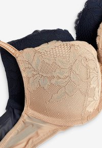 Beige und marineblauer Spitzen-BH mit floralen Mustern und Netzdetails. Verstellbare Träger und eine glatte Stoffoberfläche.