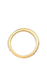 Anello in oro con bordi lisci, una superficie esterna texturizzata e piccole gemme trasparenti incastonate lungo un lato.