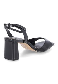 Sandale noire en cuir verni à bout ouvert avec un large talon bloc et une bride à la cheville avec fermeture à boucle, vue de côté.
