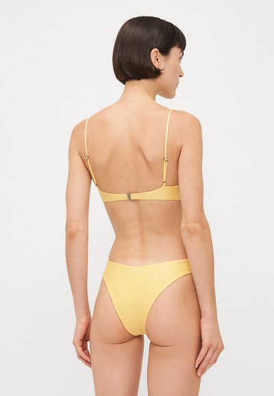 Yellow bikini set featuring thin adjustable straps and a clasp closure on the back, designed with a smooth texture and minimalist style.