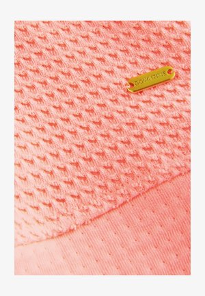 Texturirana koralna tkanina z diamantnim vzorcem, z gladkim robom in zlato etiketo z napisom "DOWNTIME."