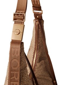 Tote bag with a textured brown fabric, featuring a gold clasp and zipper. The strap has a woven logo pattern in a matching brown shade.