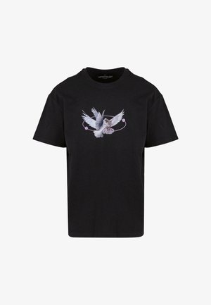 T-shirt en coton noir avec un design graphique représentant un oiseau blanc en vol, entouré d'un accent circulaire rose. Manches courtes, col rond.