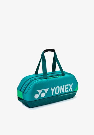 Tealgroene Yonex sporttas met twee handvatten, twee met ritssluiting afgesloten vakken, bedrukt met het logo "Yonex pro performance".