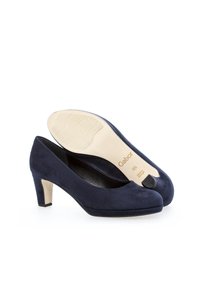 Dei tacchi alti in suede blu navy con punta arrotondata, tacco a blocco di altezza media e suola in gomma testurizzata che presenta il nome del marchio "Gabor."