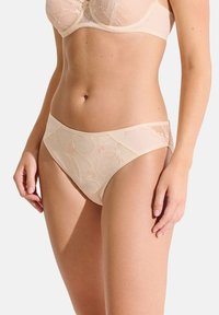 Culotte de bikini beige avec un overlay en dentelle florale, une taille lisse et des coutures décoratives. Fabriqué à partir d'un matériau doux et léger pour plus de confort.