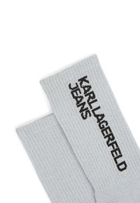 Sivé rebrované ponožky s čiernym textom "KARL LAGERFELD JEANS". Vyrobené z elastického materiálu, majú tesný strih a textúrovaný povrch.