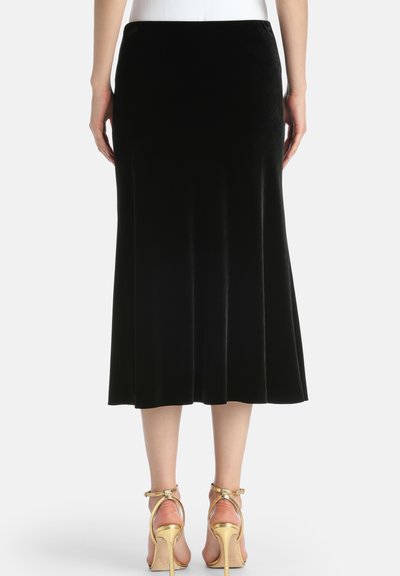 Sort velour midi-nederdel med en yderfladet design, glat tekstur og syningsdetaljer. Parret med guld højhælede sandaler.