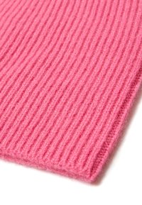 Tessuto a maglia rosa a coste con una texture morbida. I bordi sono rifiniti in modo ordinato, mettendo in mostra linee verticali equidistanti.