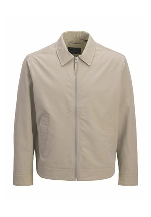 Világos bézs cipzáras dzseki hegyes gallérral, texturált anyagból, hosszú ujjú és két átlós első zsebbel.