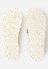 Semelles en caoutchouc blanc de tongs avec surfaces texturées, petites marques circulaires et indicateurs embossés "R" et "L" pour le pied droit et gauche.