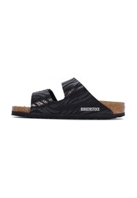 Sandali Birkenstock neri con superficie texturizzata e plantare in sughero, dotati di lati a ritaglio per la traspirabilità e suola in gomma per una migliore aderenza.