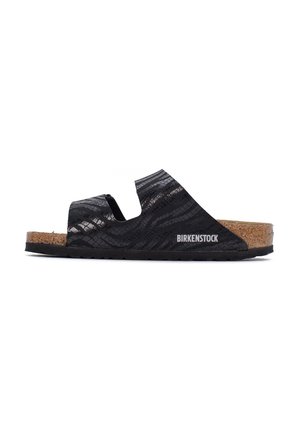 Sandali Birkenstock neri con superficie texturizzata e plantare in sughero, dotati di lati a ritaglio per la traspirabilità e suola in gomma per una migliore aderenza.
