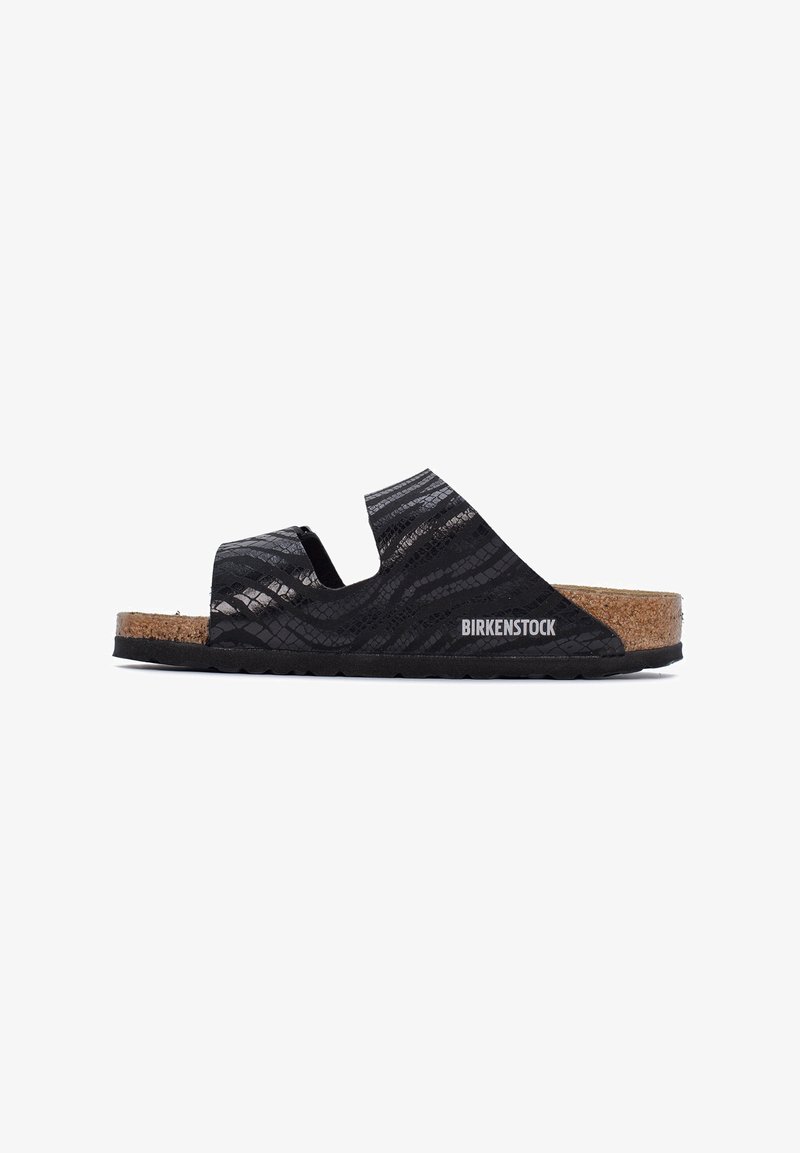 Zwarte Birkenstock-sandalen met een gestructureerd oppervlak en een kurken voetbed, met uitsparingen aan de zijkanten voor ademend vermogen en een rubberen zool voor grip.
