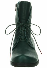 Stivale alla caviglia verde in pelle con punta piatta, lacci frontali e zip laterale. Presenta una finitura testurizzata e lacci in contrasto con punte rosse.