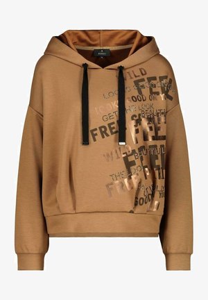 Tan cropped hoodie with black drawstrings and mixed metallic and printed text reading "FEEL," "FREEDOM," and "WILD" on the front right side.