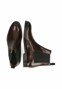 Botas Chelsea de cuero marrón con paneles laterales elásticos, punta redondeada y tacón bajo apilado. Acabado suave y detalle mínimo.