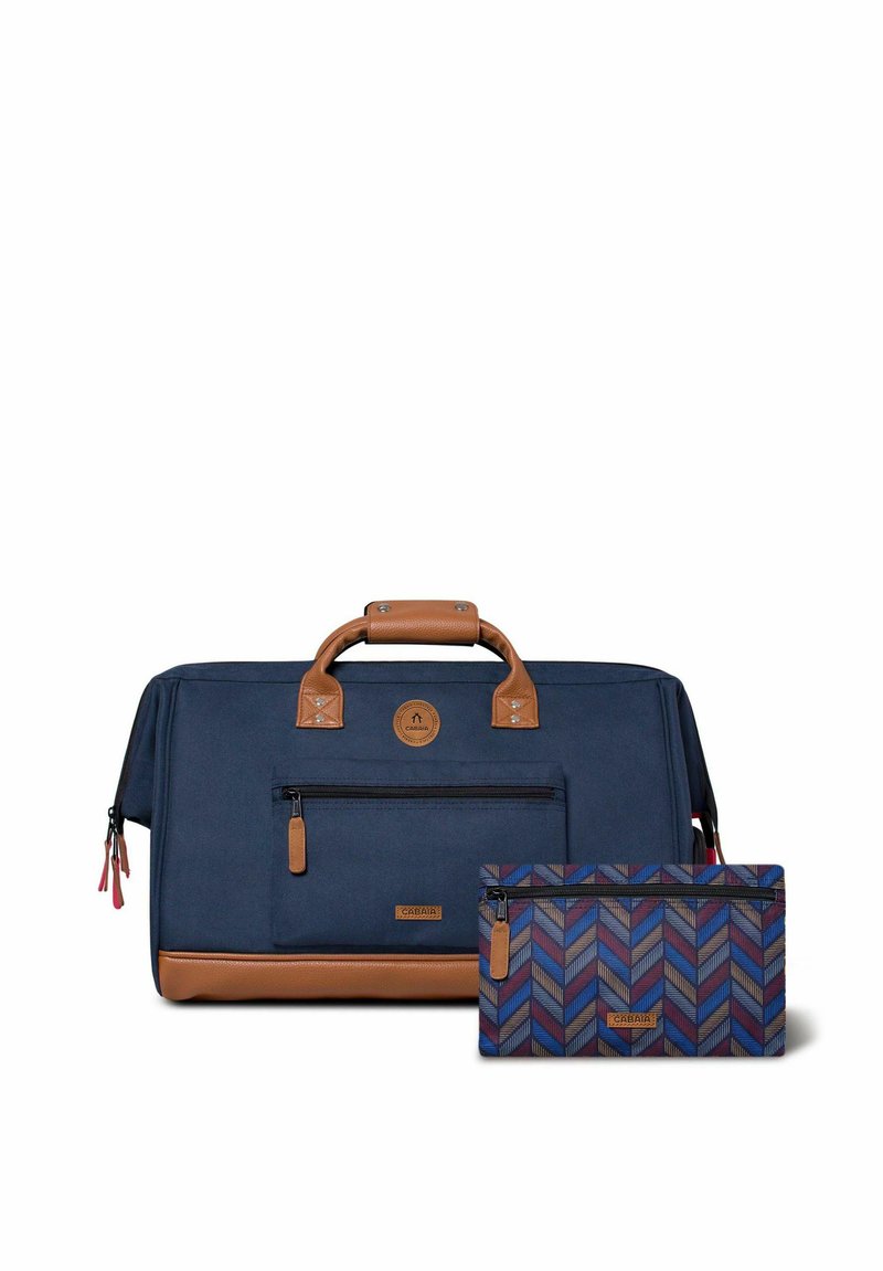 Sac de voyage en toile bleu marine avec des accents en cuir marron, une poche zippée à l'avant et une pochette assortie à motif en chevrons.