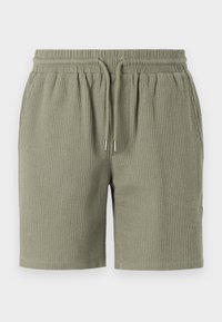 Pantalones cortos de textura de gofre en color verde oliva, con cinturilla elástica, cordones y un corte relajado. Dobladillo liso en las piernas.