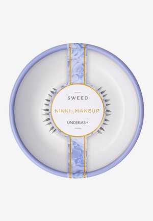 Unterwimpernprodukt in einem runden, weißen Tablett. Enthält schwarze synthetische Wimpern mit einem lavenderfarbenen Band, gekrönt von einem mit Blumenmustern versehenen Etikett.