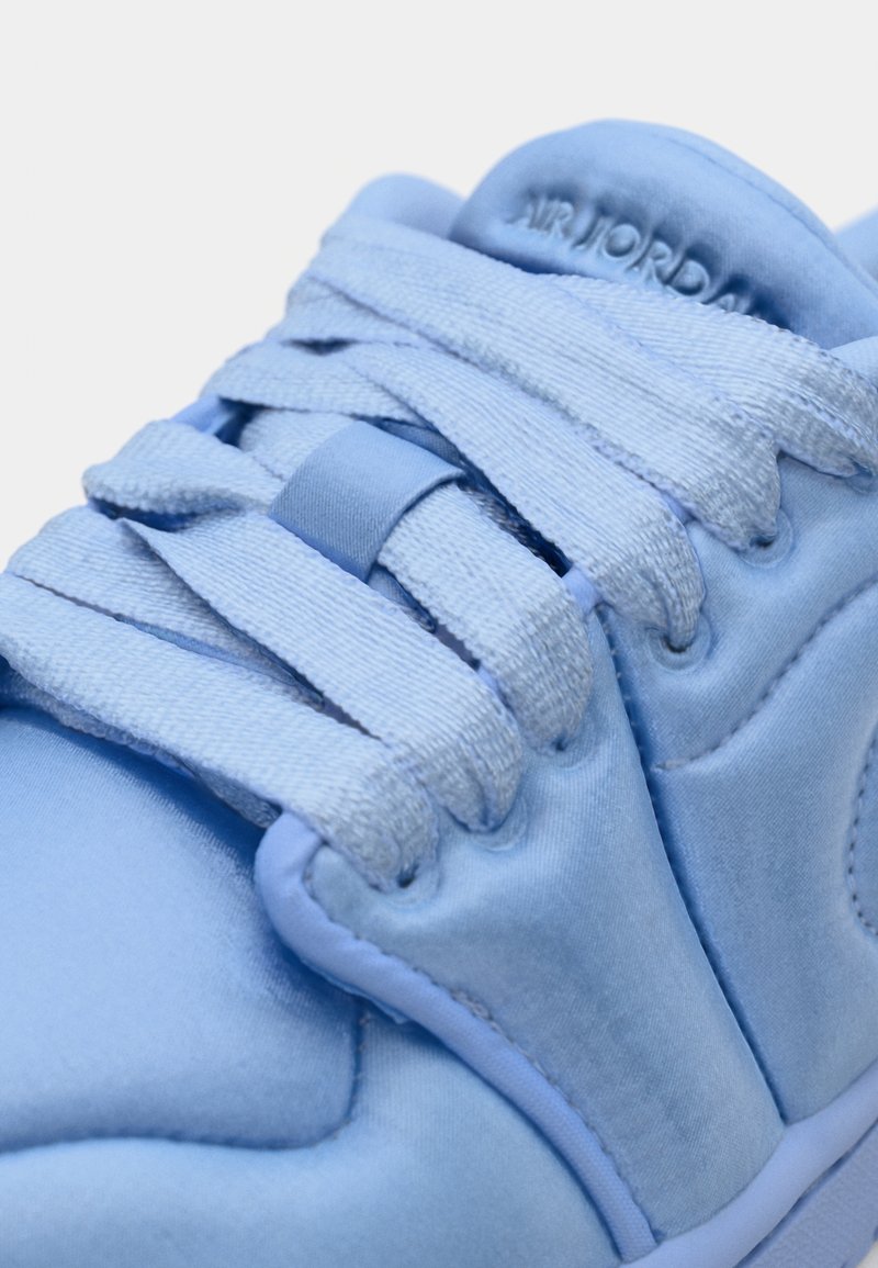 Baskets de sport bleu clair avec un tissu lisse, un bout arrondi et des lacets plats. Présente le logo "AIR JORDAN" embossé sur la languette.