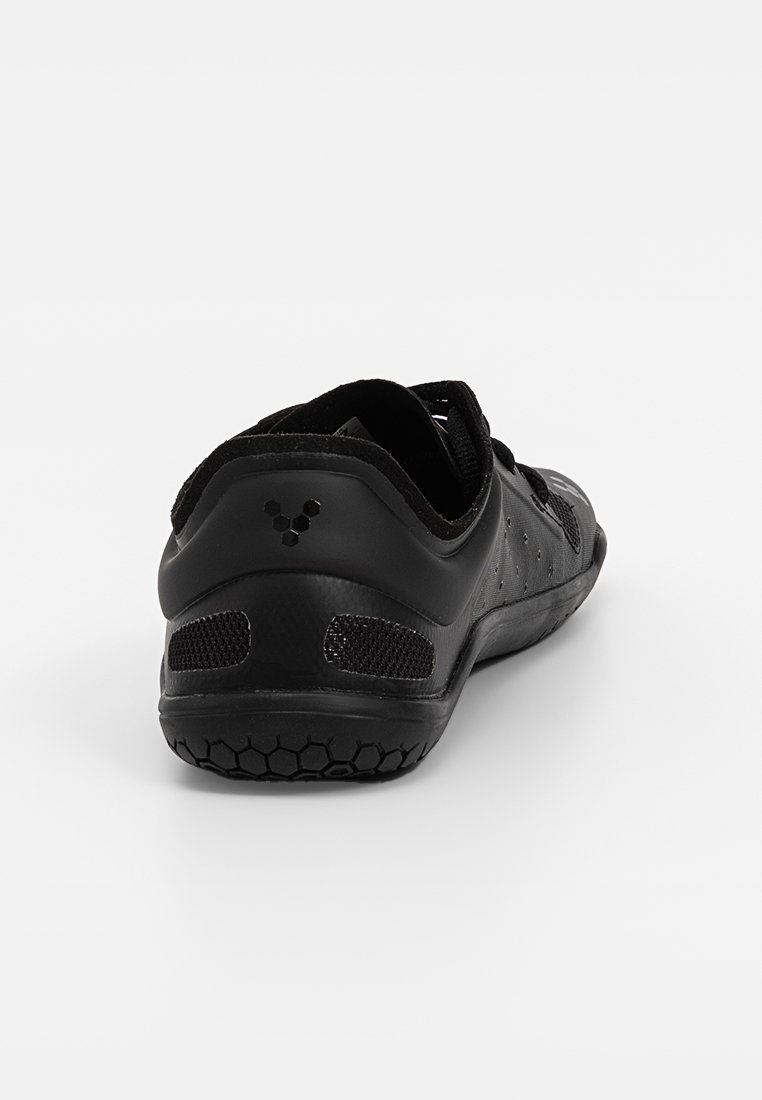 Schwarzer Sportschuh mit strukturiertem Obermaterial, Mesh-Akzenten und flexibler Sohle mit Wabenmuster. Verstellbarer Riemen für eine optimale Passform.