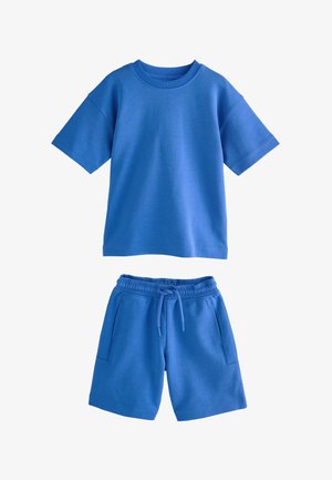 Gładki niebieski t-shirt z krótkim rękawem w połączeniu z dopasowanymi niebieskimi szortami z elastycznym pasem, sznurkiem i bocznymi kieszeniami.