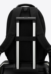 Sac à dos noir avec un panneau arrière en maille, des bretelles ajustables et une poignée rétractable en argent attachée à une base de valise noire brillante.