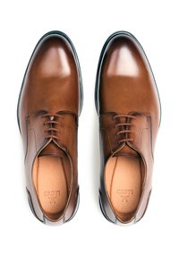 Chaussures habillées en cuir marron avec une finition lisse, bout rond et lacets. L'intérieur présente une doublure de couleur claire ; un détail de logo subtil est présent.