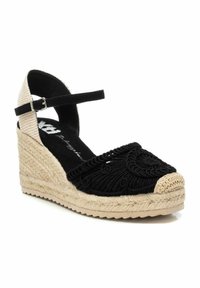 Espadrille de cuña de tela negra con detalles texturizados, suela intermedia de yute y tira de tobillo a cuadros. Punta redondeada con un acento de color beige claro.