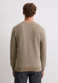 Pull en maille marron clair avec un motif texturé, col rond et poignets côtelés. Le design est simple et cintré à la taille.