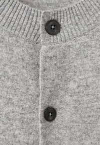 Cardigan gris tricoté avec col côtelé et deux boutons noirs fermés au centre devant.