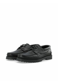 Bateaux en cuir noir avec un dessus texturé, un bout arrondi, un laçage à l'avant et une semelle en caoutchouc robuste. Équipés d'œillets en métal et de détails de couture.