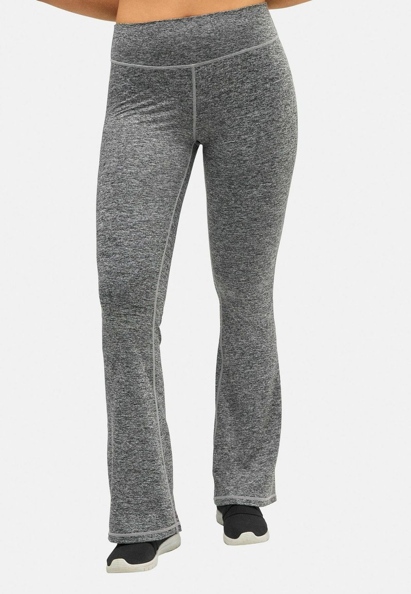 Pantalones acampanados grises hechos de una tela texturizada, con una cintura alta y costuras en contraste. Combinados con zapatos negros.