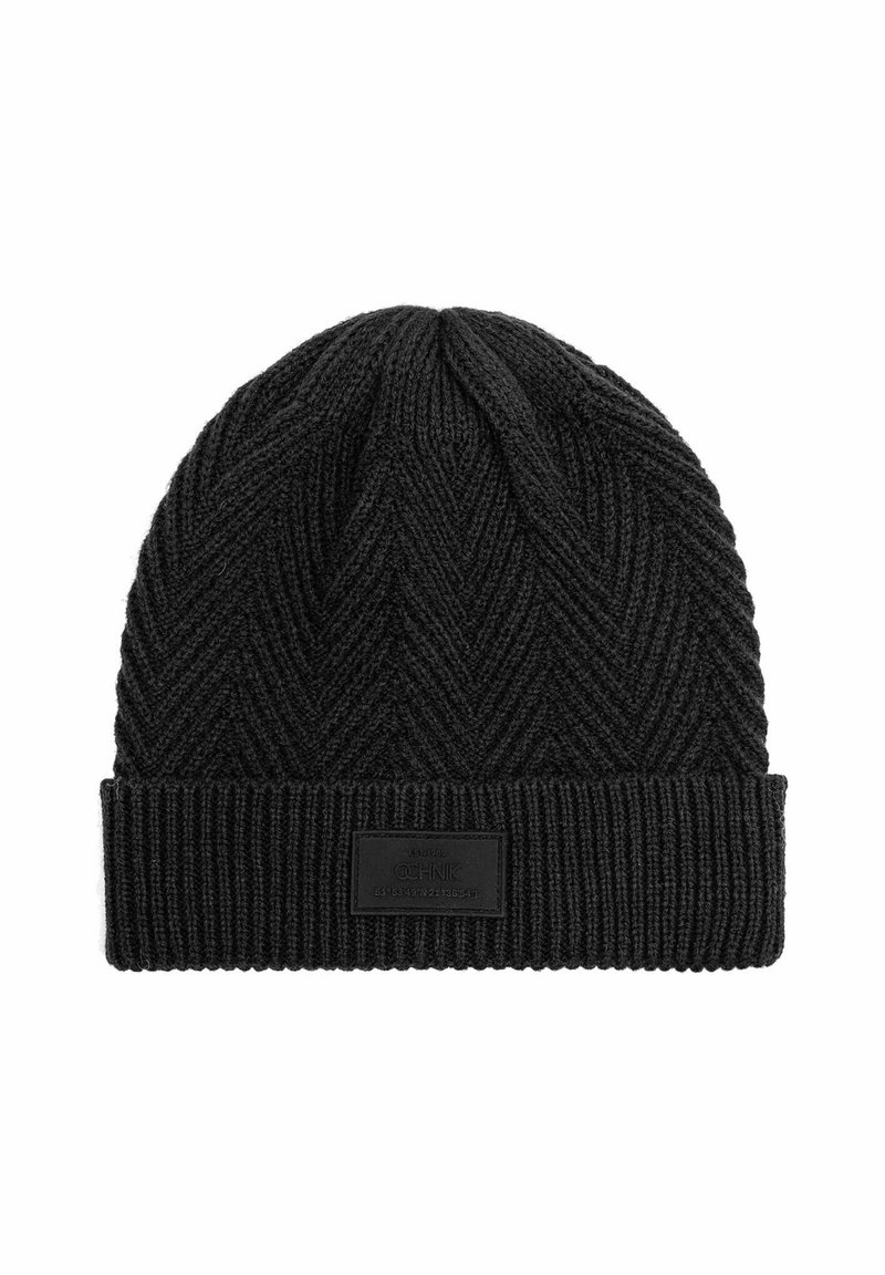 Czarna dziana czapka w warkoczowy wzór, z prążkowanym mankietem i prostokątną skórzaną metką z przodu.