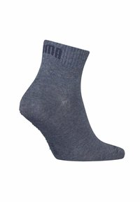 Dunkelblaue Knöchelsocke, geraffter Bund, glatte Textur, verstärktes Fersen- und Zehenbereich, Logo in einer kontrastierenden Farbe nahe der oberen Kante.