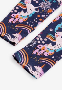 Leggings en tissu extensible coloré présentant un fond marine avec des licornes, des fleurs et des arcs-en-ciel dans des teintes vives de rose, orange et bleu.
