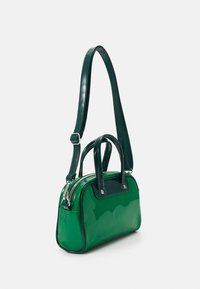 Zelená lakovaná kabelka obdélníkového tvaru s dvojitými horními uchy a nastavitelným ramenním popruhem. Obsahuje zipové uzávěr.