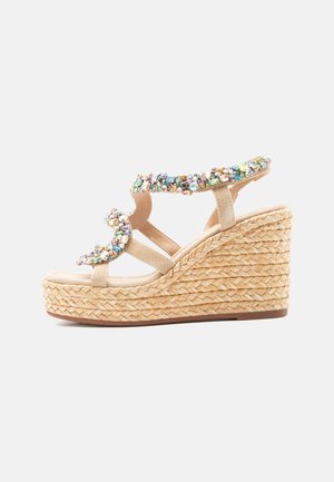 Beige kilehæl sandal med flettet platåsål og flere remmer pyntet med flerfargede edelstener.